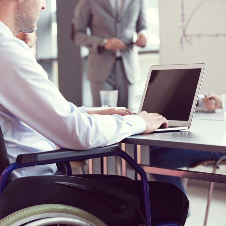 Image of a person in wheelchair working on laptop