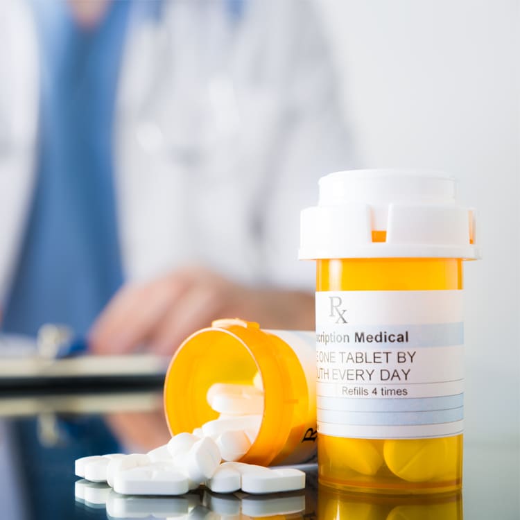 Image of an open prescription bottle with pills next to it