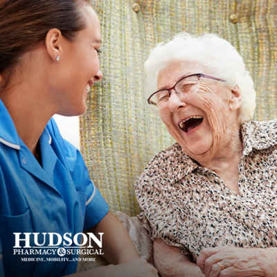 Senior woman laughing outdoors with facility caregiver