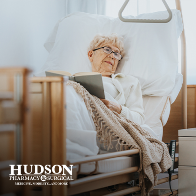 Senior woman lying in hospital bed at home reading a book
