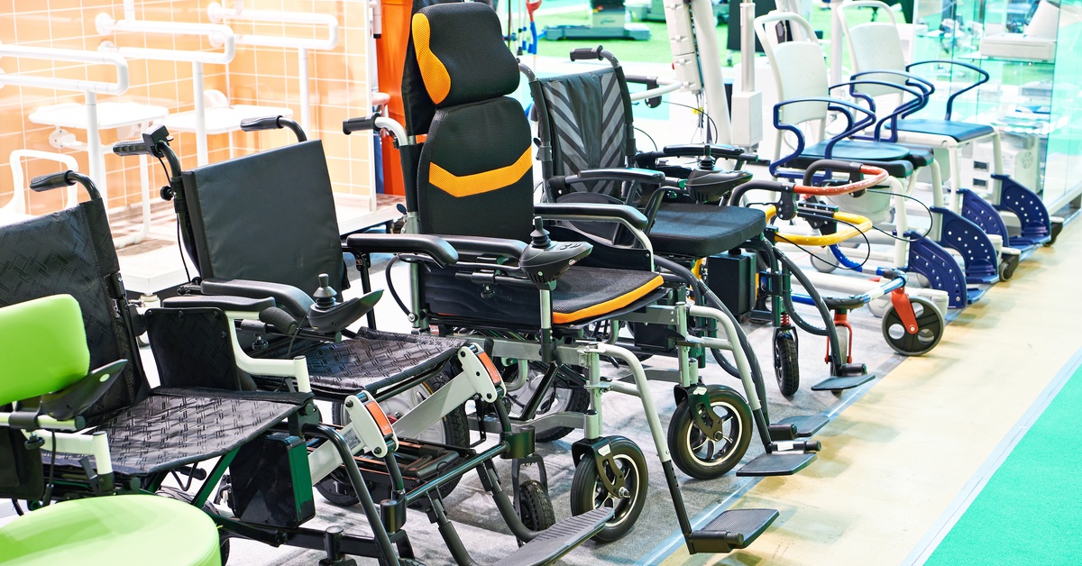 Close-up of several different types of wheelchairs lined up in a row in a mobility equipment showroom.